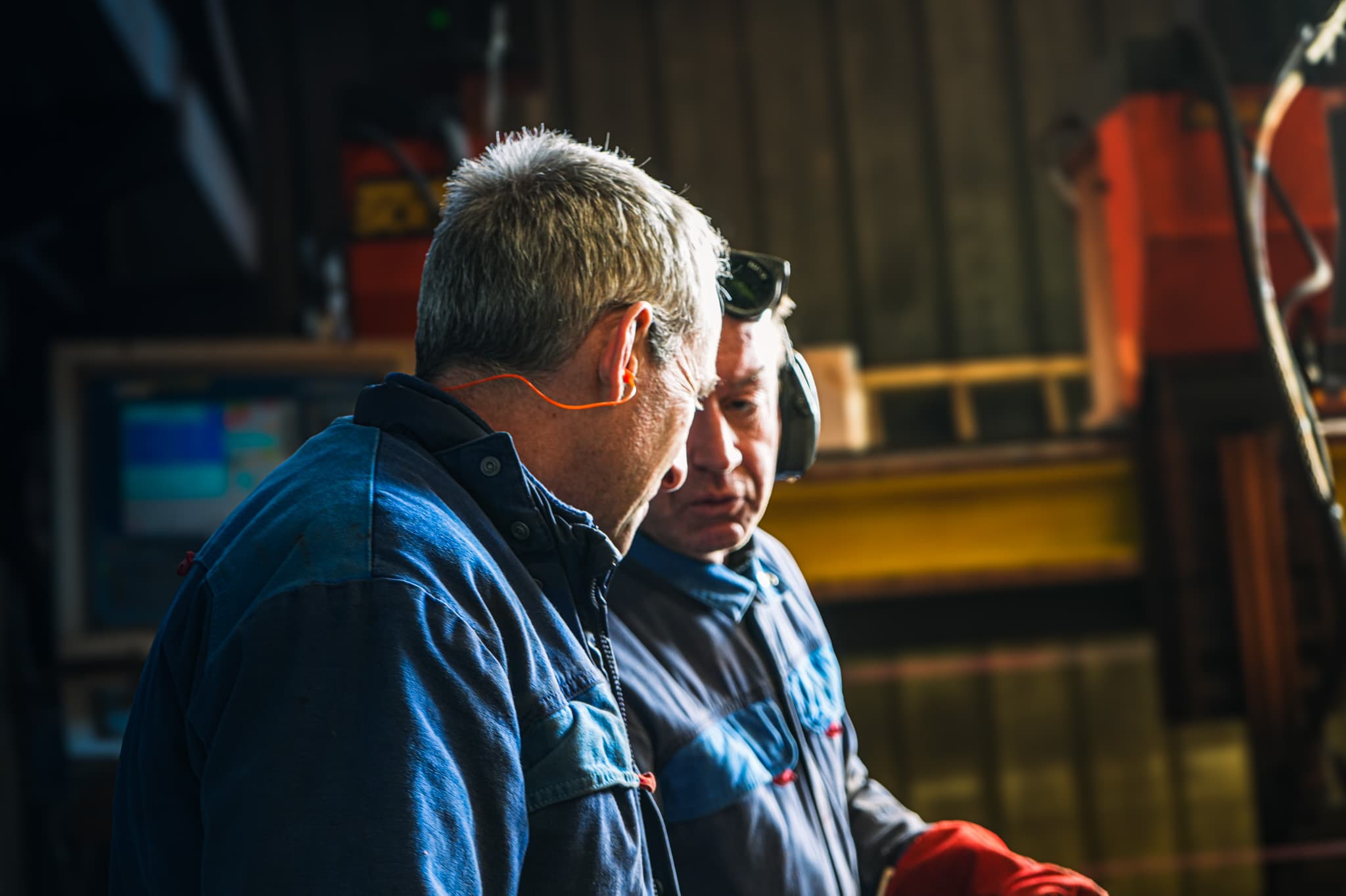Deux opérateurs de l’atelier devant un poste de découpe