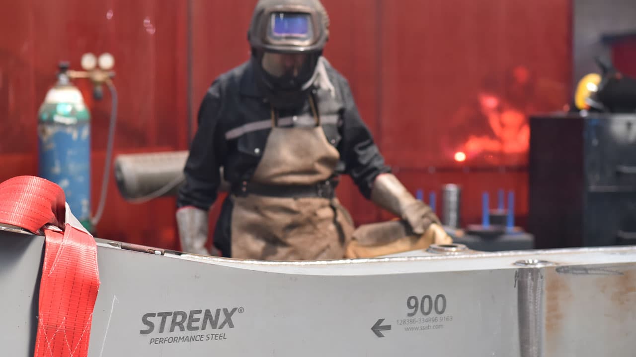 Soudeur assemblant une poutre en acier à haute limite élastique Strenx® 900