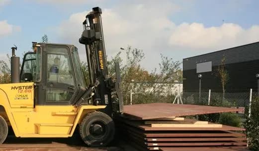 Chariot élévateur devant le stock de tôles